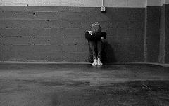 Image: Adult boy sitting alone in building